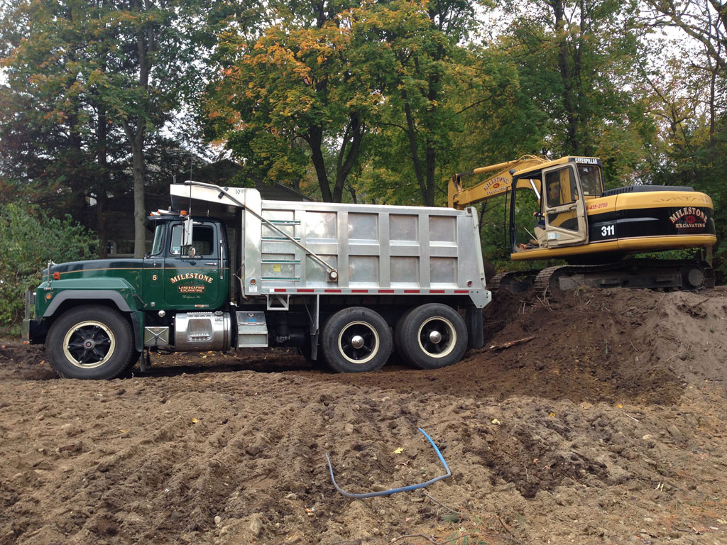 excavator-loading-truck | Milestone Landscaping